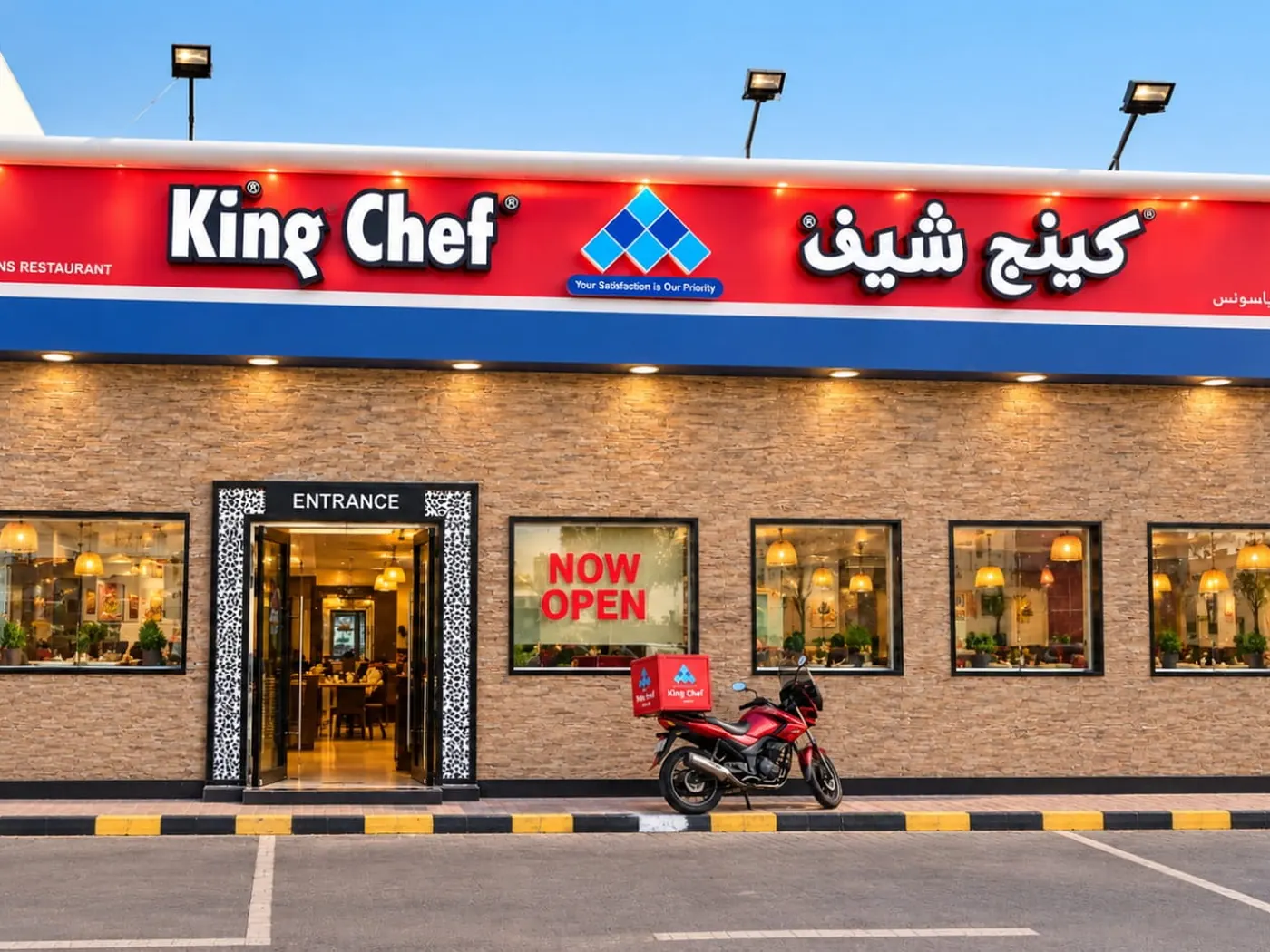 King Chef DIP 2 at night: the lit facade, awnings and planters along the front